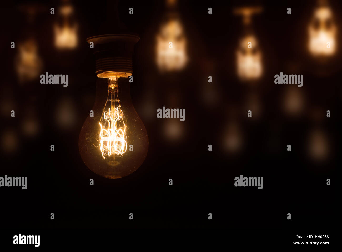 Vintage Glühlampe beleuchtet auf dunklem orange unscharfen Hintergrund Stockfoto