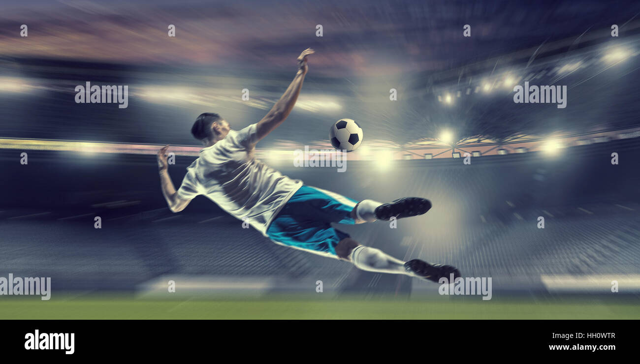 Fußballspieler im Stadion, die Kugel schlägt. Mixed-media Stockfoto
