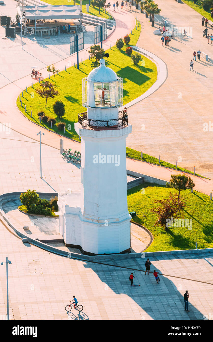 Batumi, Adscharien, Georgia. Draufsicht der alten Pizunda Leuchtturm In Wunder-Park. Menschen Fuß entlang der Promenade, beleuchtet durch die untergehende Sonne im goldenen Stunde A Stockfoto