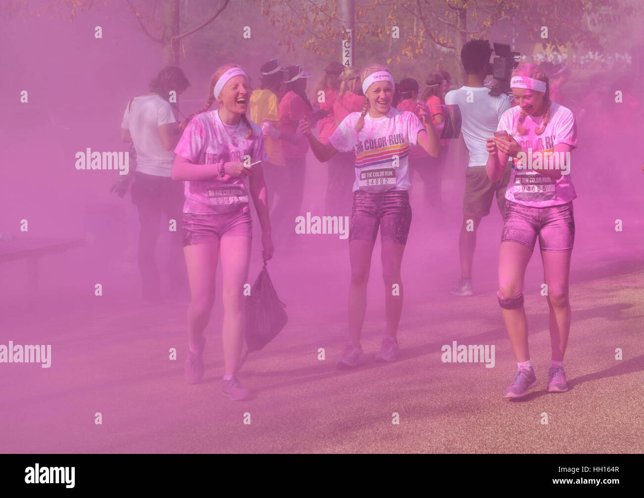 Lachend Läuferinnen bedeckt mit rosa Farbe in London Farbe laufen 2014 Stockfoto