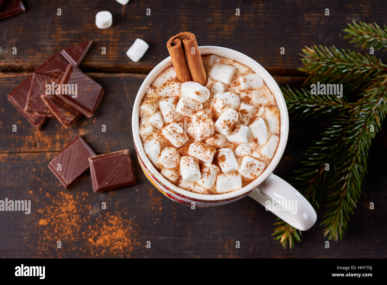 Tasse heiße Schokolade mit Marshmallows und Zimtstange auf alten Holztisch. Stockfoto