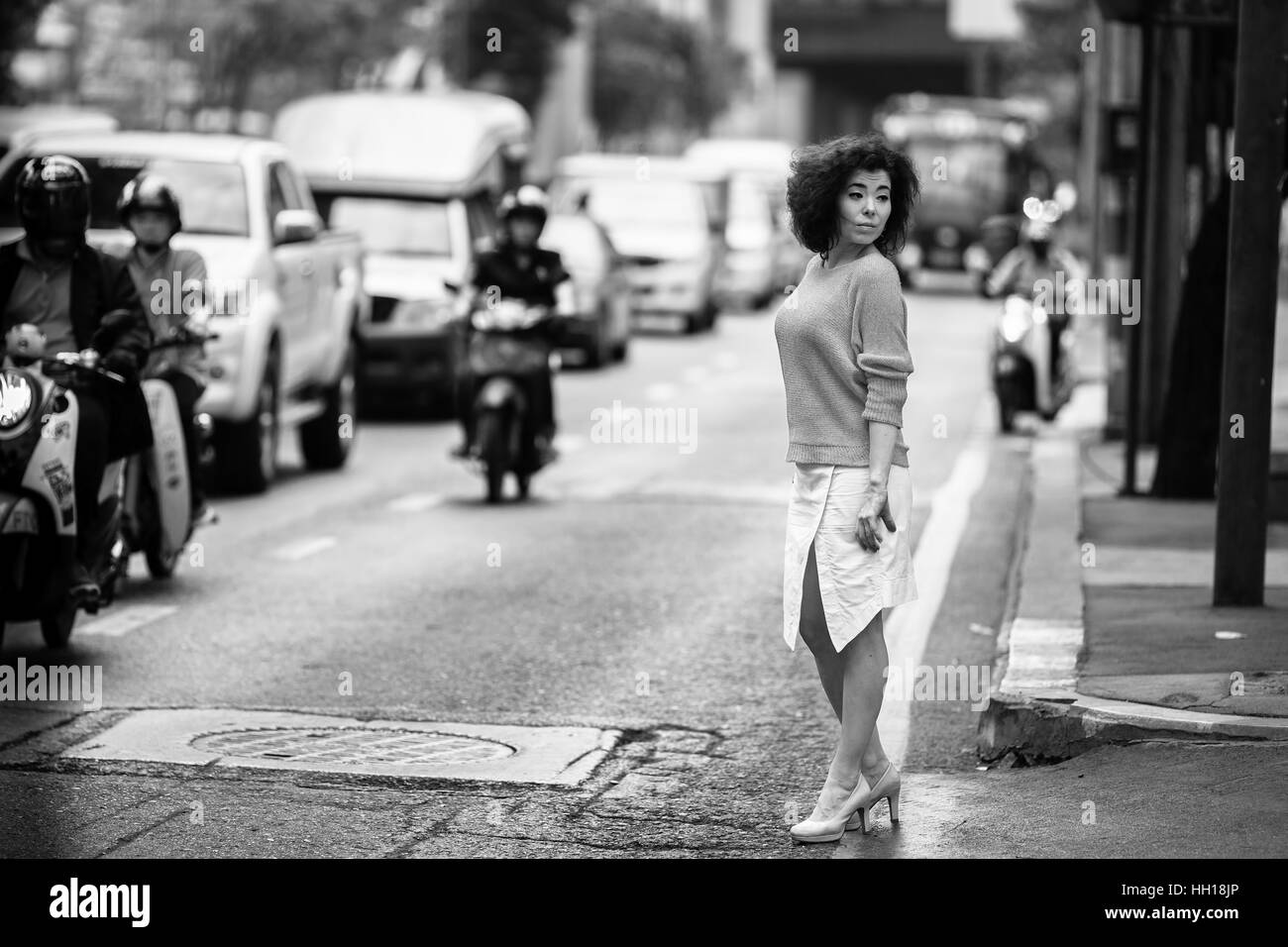 Asiatische Frau auf einer belebten Straße. Schwarz-weiß. Stockfoto