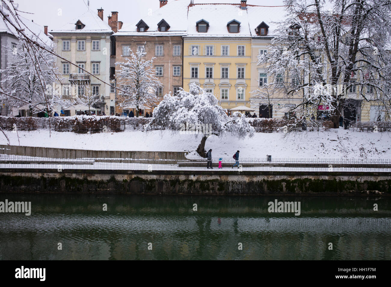 Ansicht der rechten Ufer des Flusses Ljubljanica und Altbauten in Ljubljana/Slowenien, bedeckt mit Schnee Stockfoto