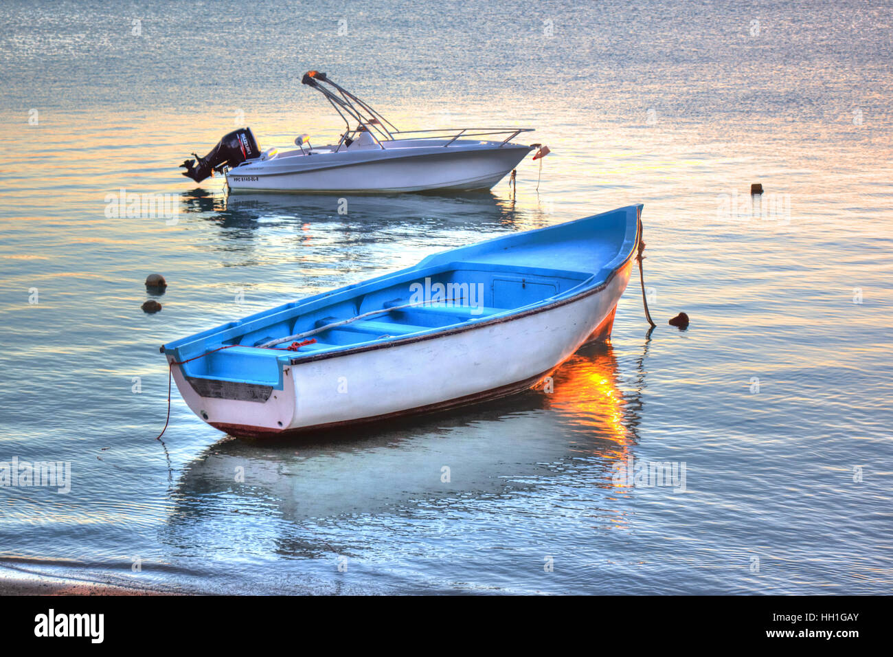 Wir sahen die untergehende Sonne und diese ruhige Szene entfaltet, Boote auf einem spiegelglatten See reflektiert. Stockfoto