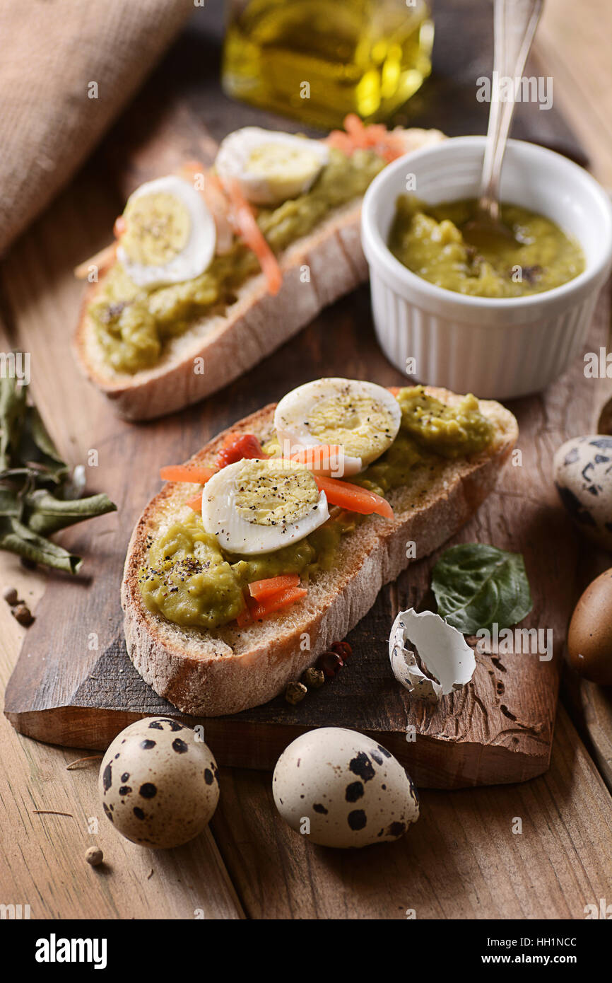 Schnittbrot mit Pea-Creme und Wachteln Eiern auf dem Tisch Stockfoto