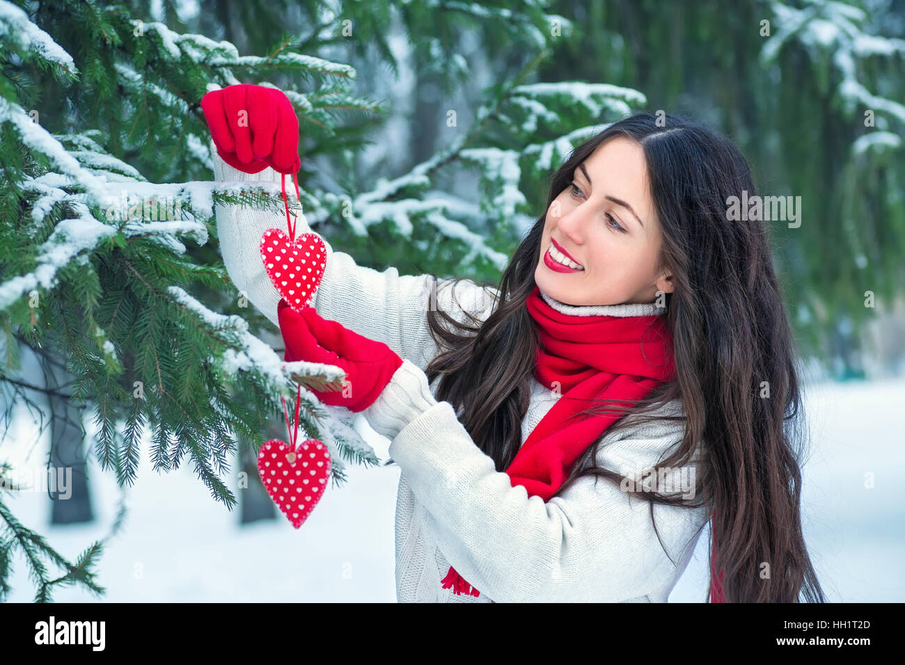 Mädchen mit roten Herzen im Winter im freien Stockfoto