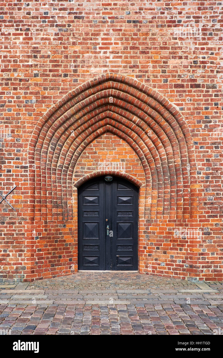 Die Eingangstür aus schwarzem lackiertem Holz in den Kirchturm bauen aus roten Ziegelsteinen, von Helsingör Kathedrale in Dänemark Stockfoto