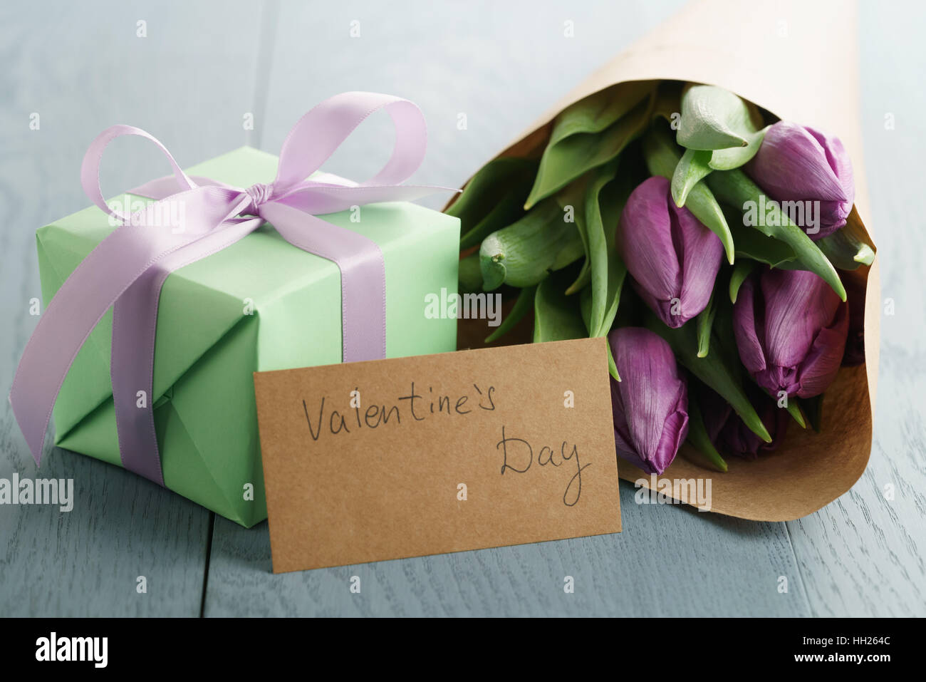 Tulpe Blumen mit grünen Box und Papier Geschenkkarte auf blauen Holztisch zum Valentinstag Stockfoto