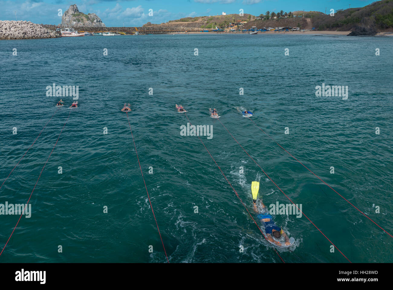 Touristen Schnorcheln vor der brasilianischen atlantischen Insel Fernando De Noronha, jeweils gezogen von einem Boot, Pernambuco, Brasilien Stockfoto