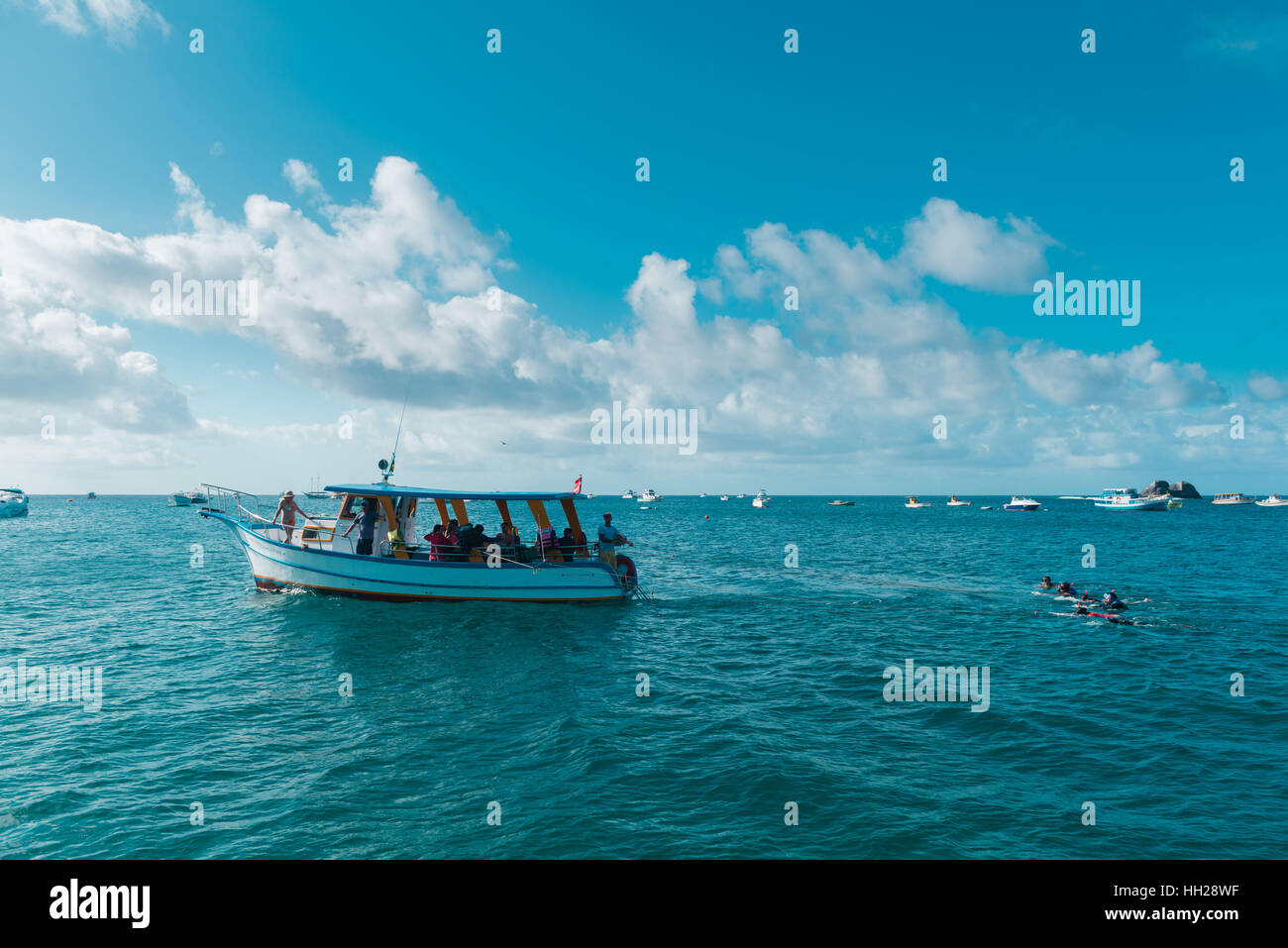 Touristen Schnorcheln vor der brasilianischen atlantischen Insel Fernando De Noronha, jeweils gezogen von einem Boot, Pernambuco, Brasilien Stockfoto