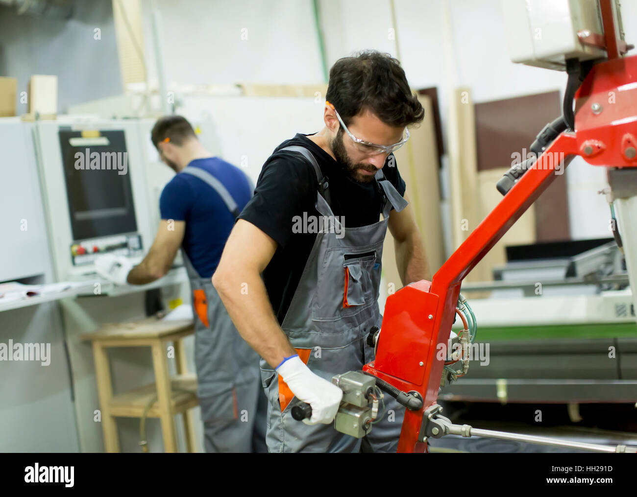 Junge männliche Arbeitnehmer arbeiten in einer Fabrik für die Herstellung von Möbeln Stockfoto