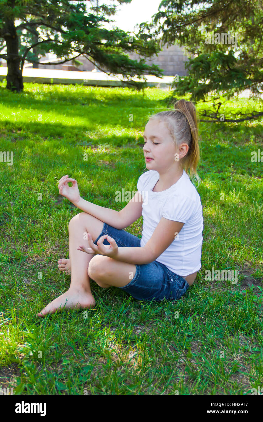 Foto von netten Mädchen in Lotus-pose Stockfoto