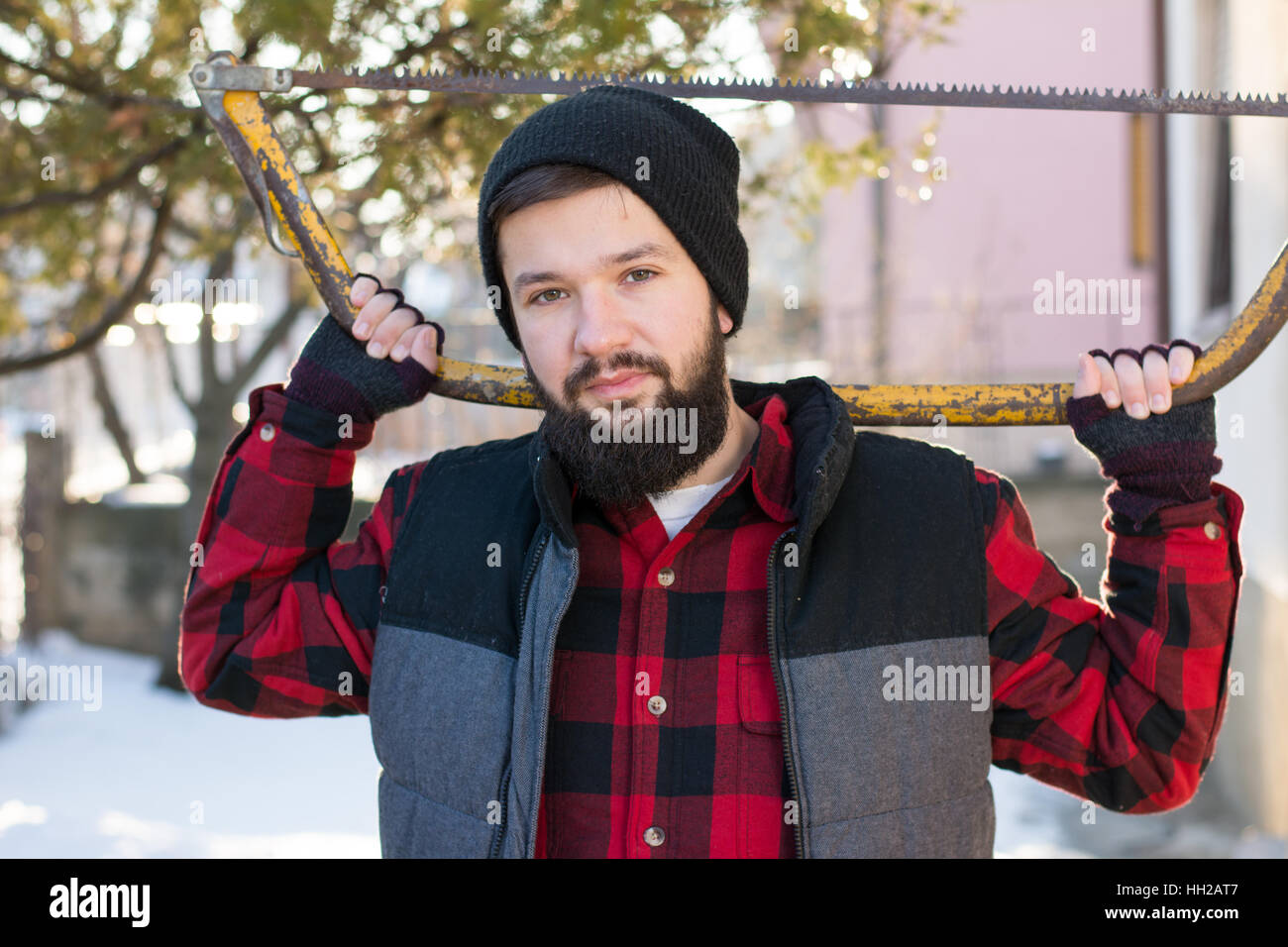 Mann mit einer Handsäge zum Schneiden von Holz im Garten Stockfoto