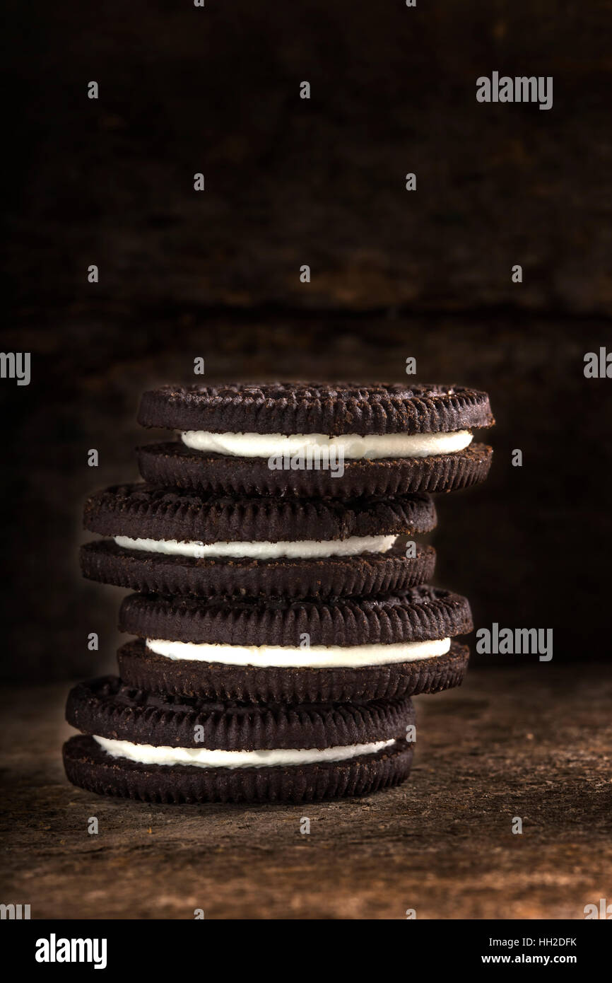 Schokoladen-Cookies mit weißer Füllung auf hölzernen Hintergrund Stockfoto