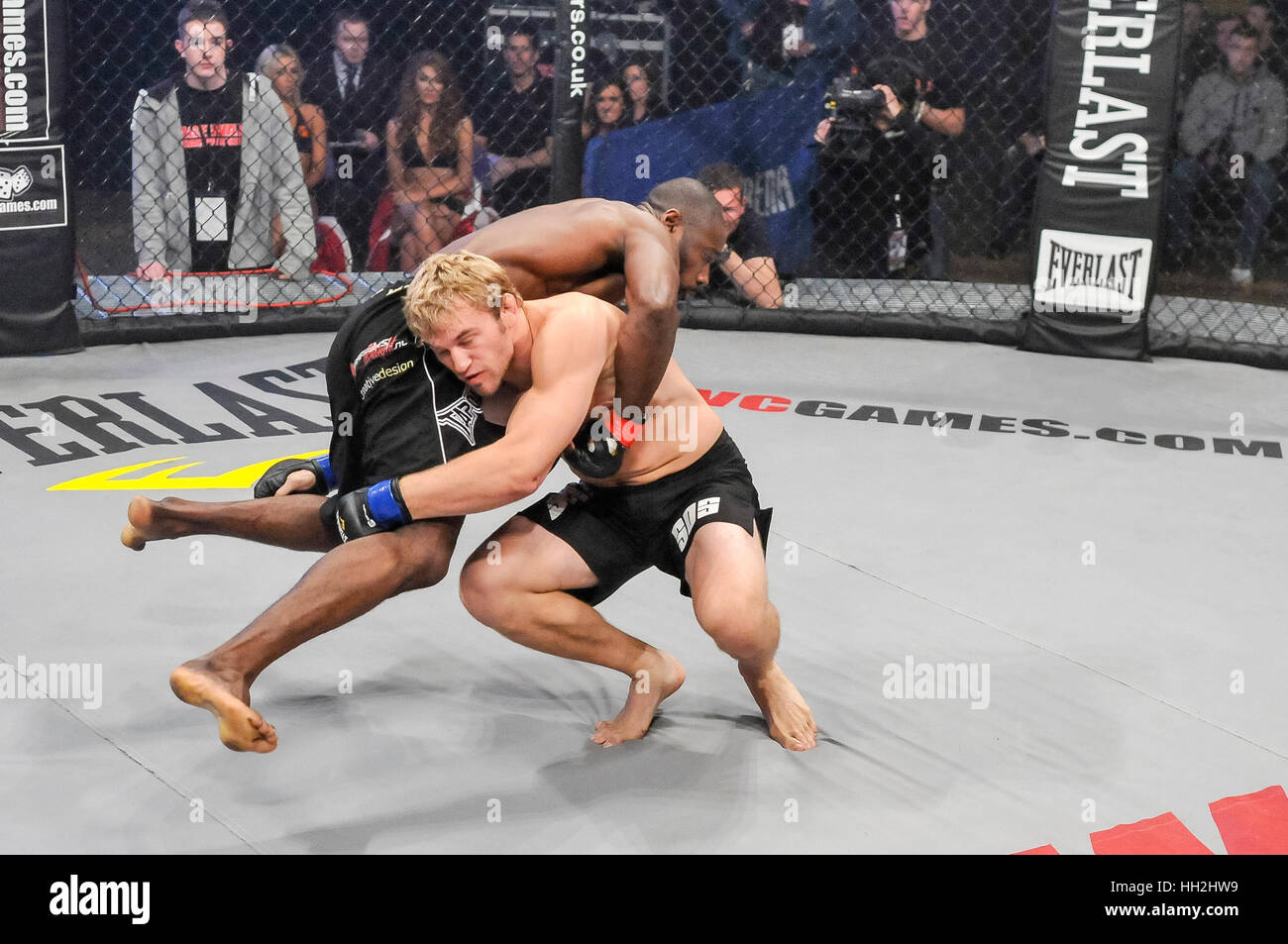 MMA Käfig Kämpfer hebt seinen Gegner in die Luft. Stockfoto