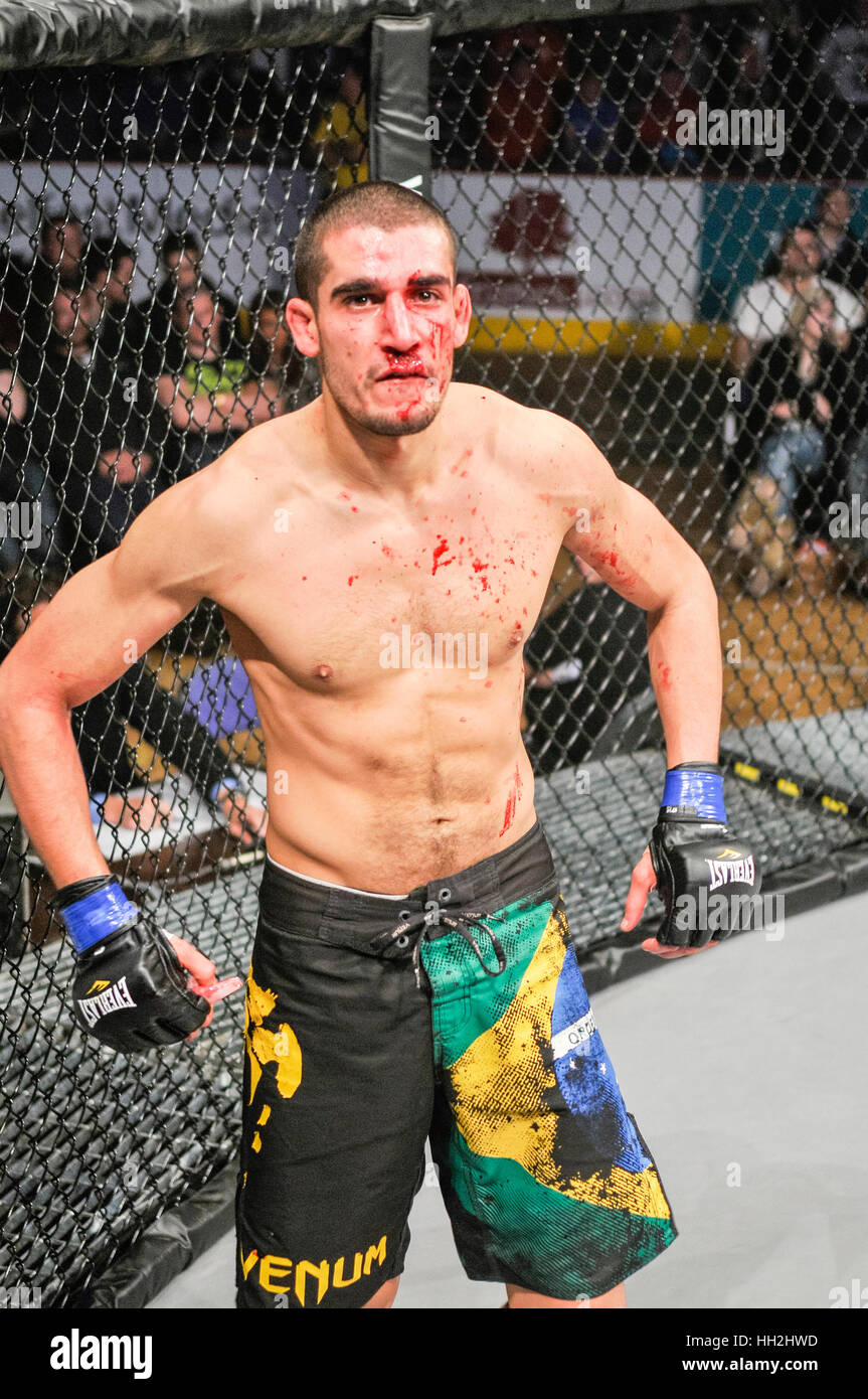 MMA Käfig-Kämpfer bedeckt im Blut nach der Einnahme eines Schlages in seine Nase brechen in den Prozess. Stockfoto