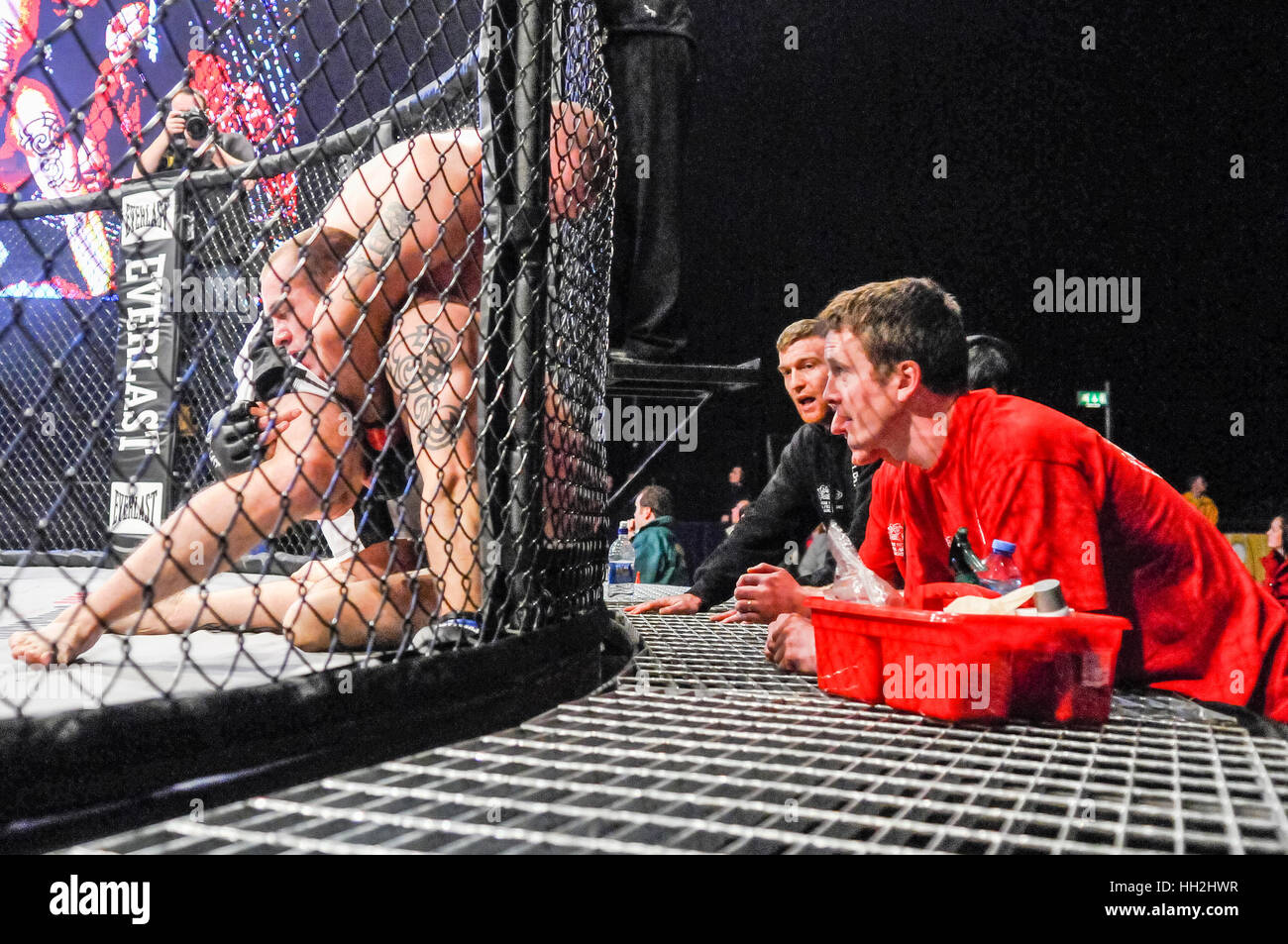 Trainer beraten ihre Kämpfer in den Ring während eines Kampfes MMA Käfig. Stockfoto