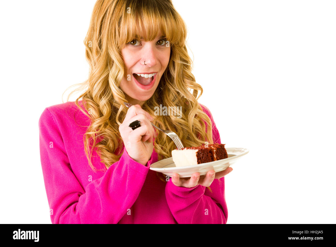 Eine attraktive blonde Frau, die einen Stück Kuchen zu genießen Stockfoto