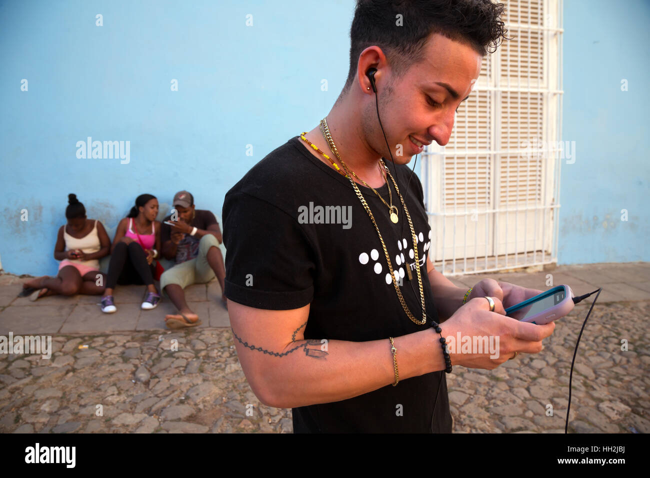 Junge Menschen spielen mit ihrem Handy in Trinidad, Kuba Stockfoto