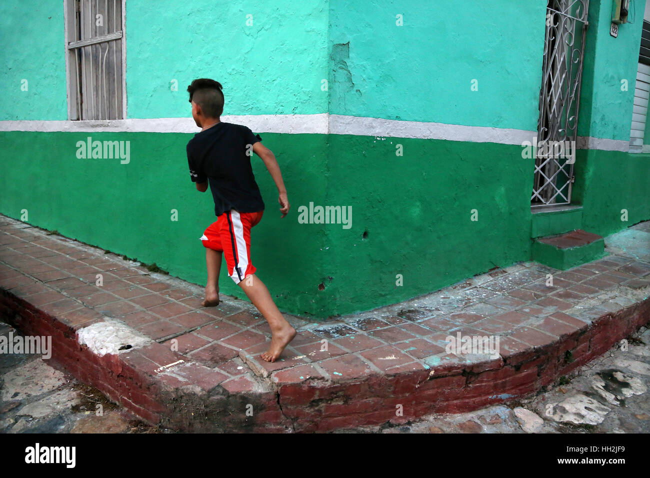 Ein Junge läuft durch die Straßen von Camagüey, Kuba Stockfoto