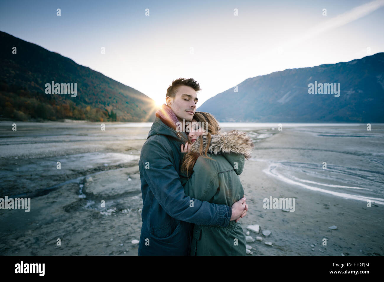 Junge liebende Paar umarmt, See und die Berge im Hintergrund, Liebe und Romantik-Konzept Stockfoto
