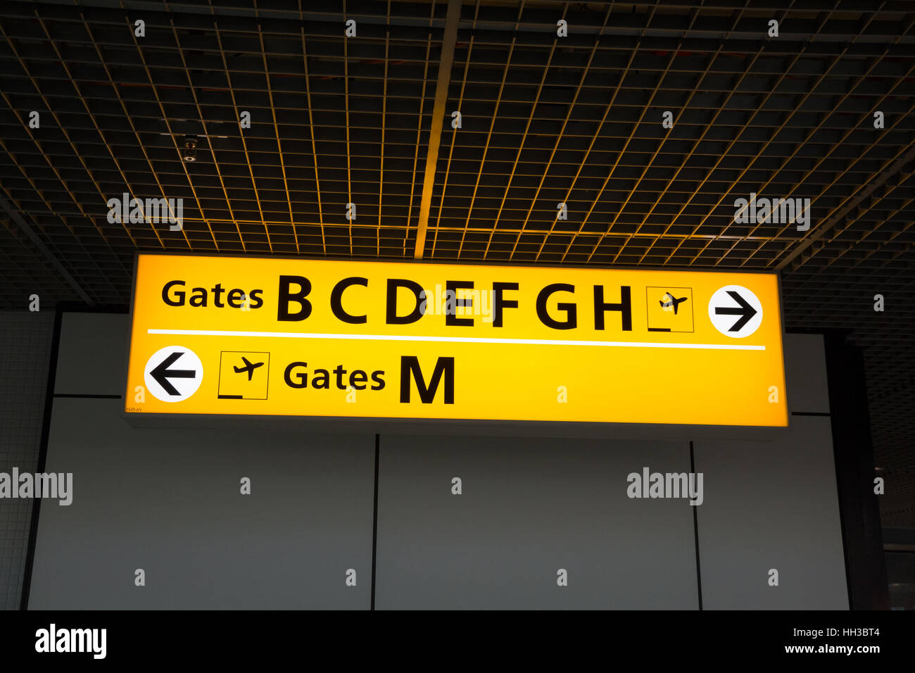 Gelb beleuchtet Schild am Flughafen mit Tor Zahlen für abfliegende Flüge Stockfoto