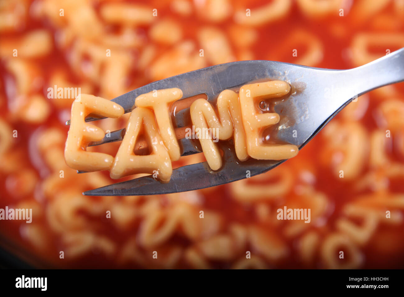 Spaghetti-Brief, die Schreibweise des Wortes "Eat Me" mit den Buchstaben auf einer Gabel aufgehalten. Stockfoto