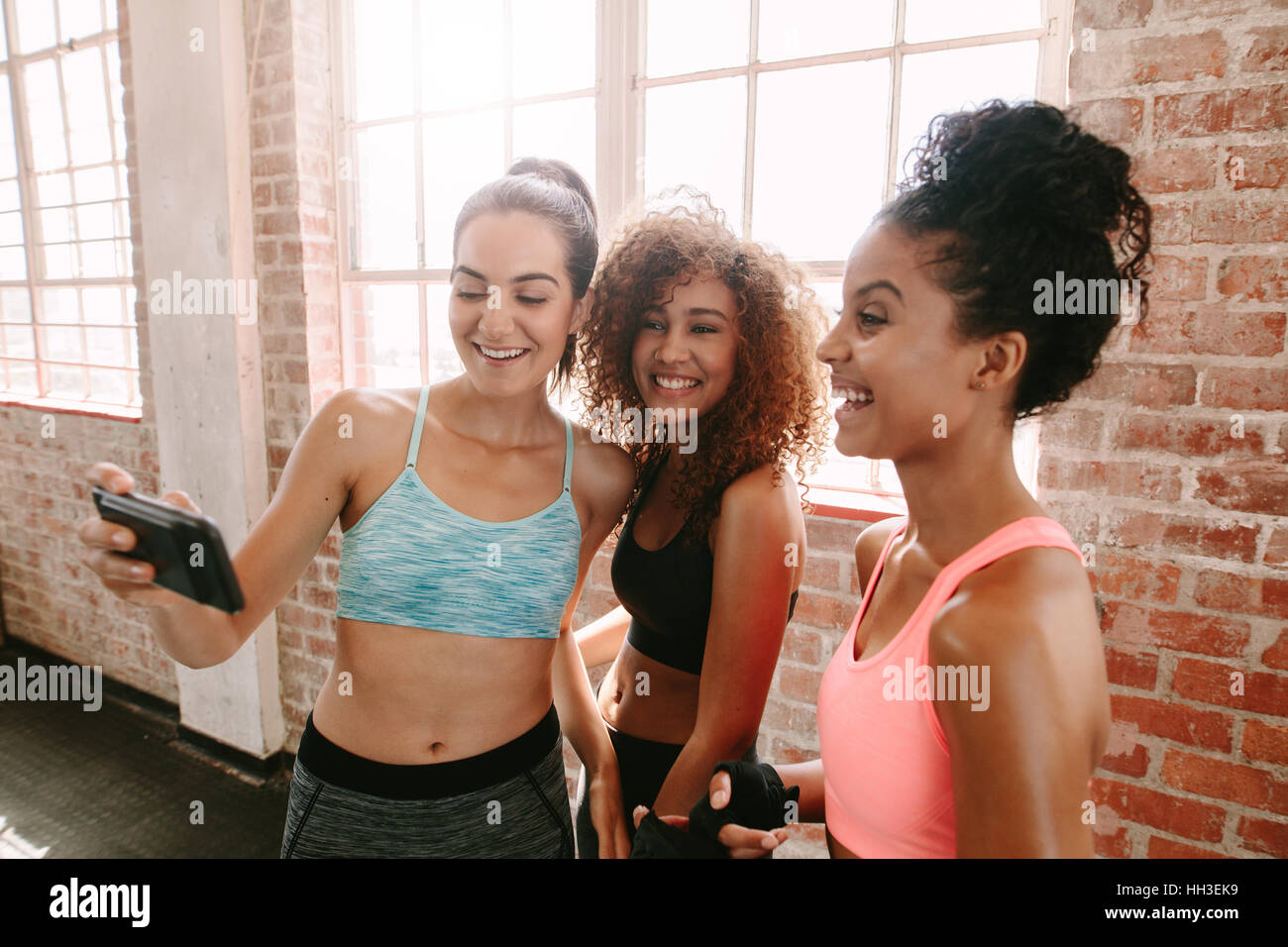 Gruppe von Frauen in Fitness-Klasse nehmen Selfie während der Pause. Freundinnen unter einem Selfie nach Fitness-Training im Fitness-Studio. Stockfoto