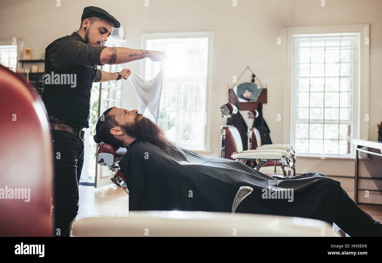 Barbier, finishing Pflege und kümmert sich um Kunden im Friseursalon Stockfoto