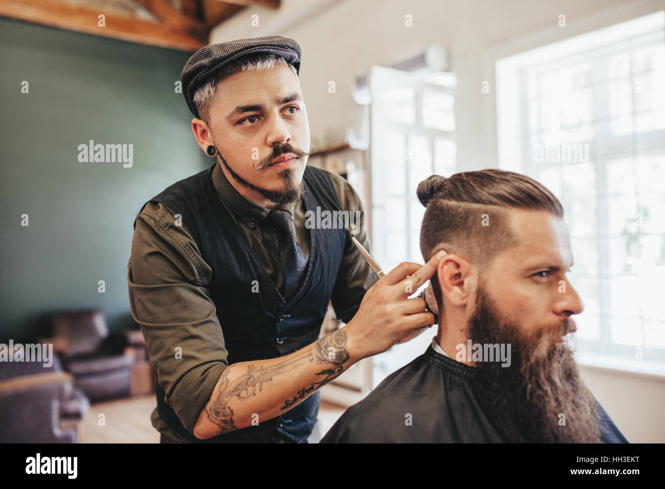 Friseur, Überprüfung der Symmetrie der Haarschnitt seines Mandanten im Bärtiger Mann
