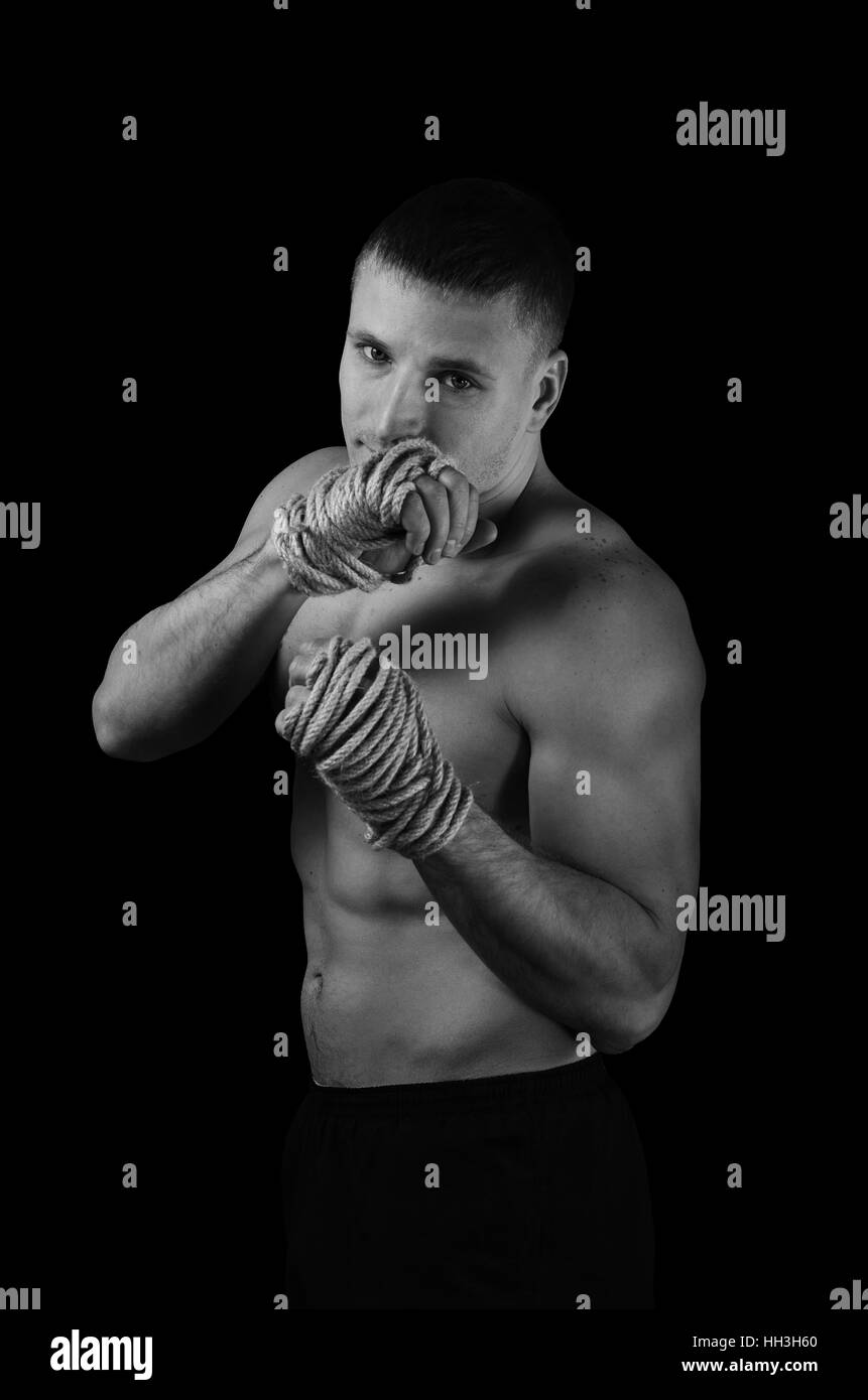 Schwarz / weiß Foto eines jungen Athleten mit Hanfseilen auf Händen für Muay Thai Stockfoto