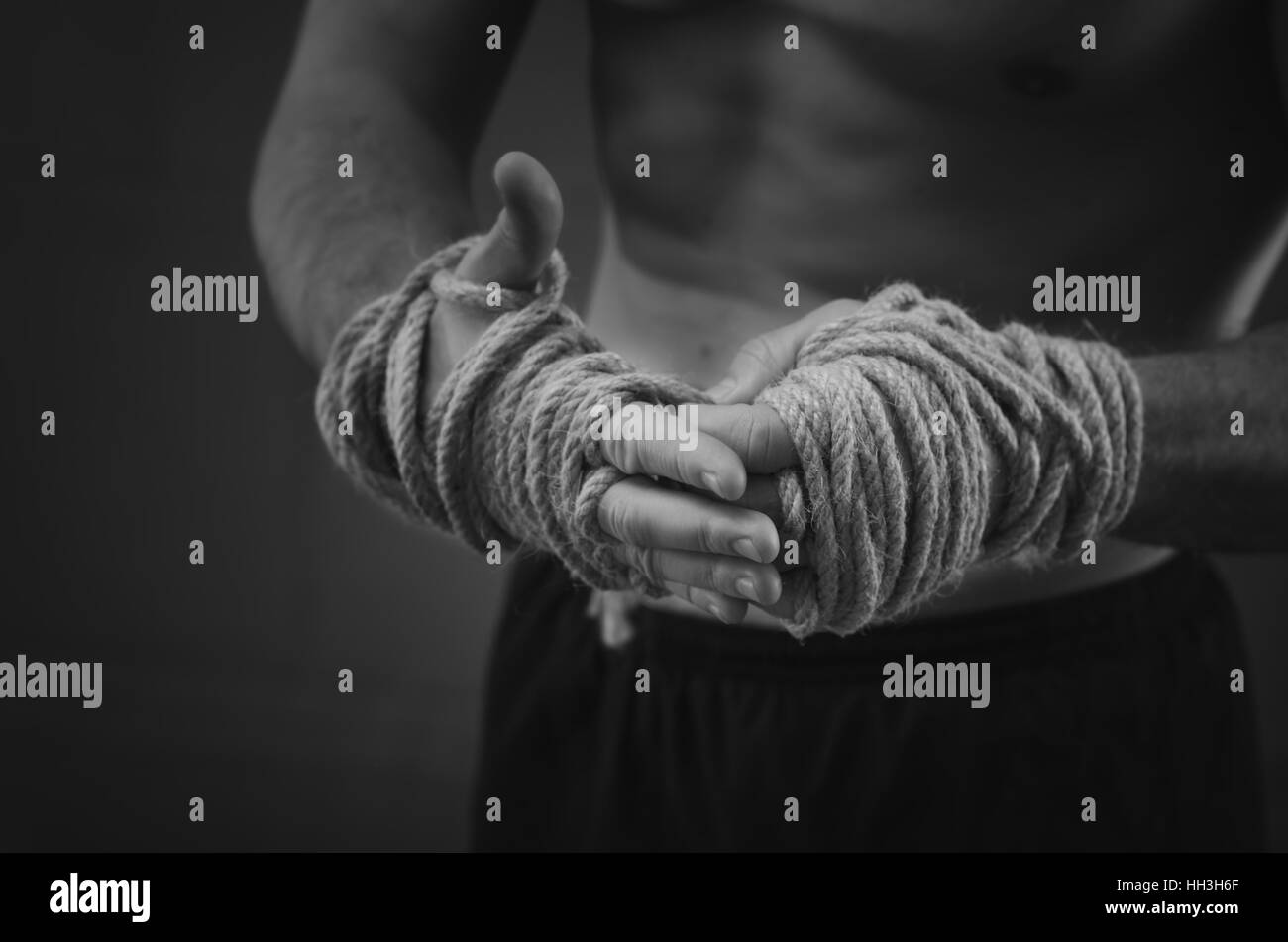 Nahaufnahme eines jungen Thai Boxer Hände Hanf, die Seile vor dem Kampf oder Training gewickelt werden. Schwarz / weiß Stil Stockfoto