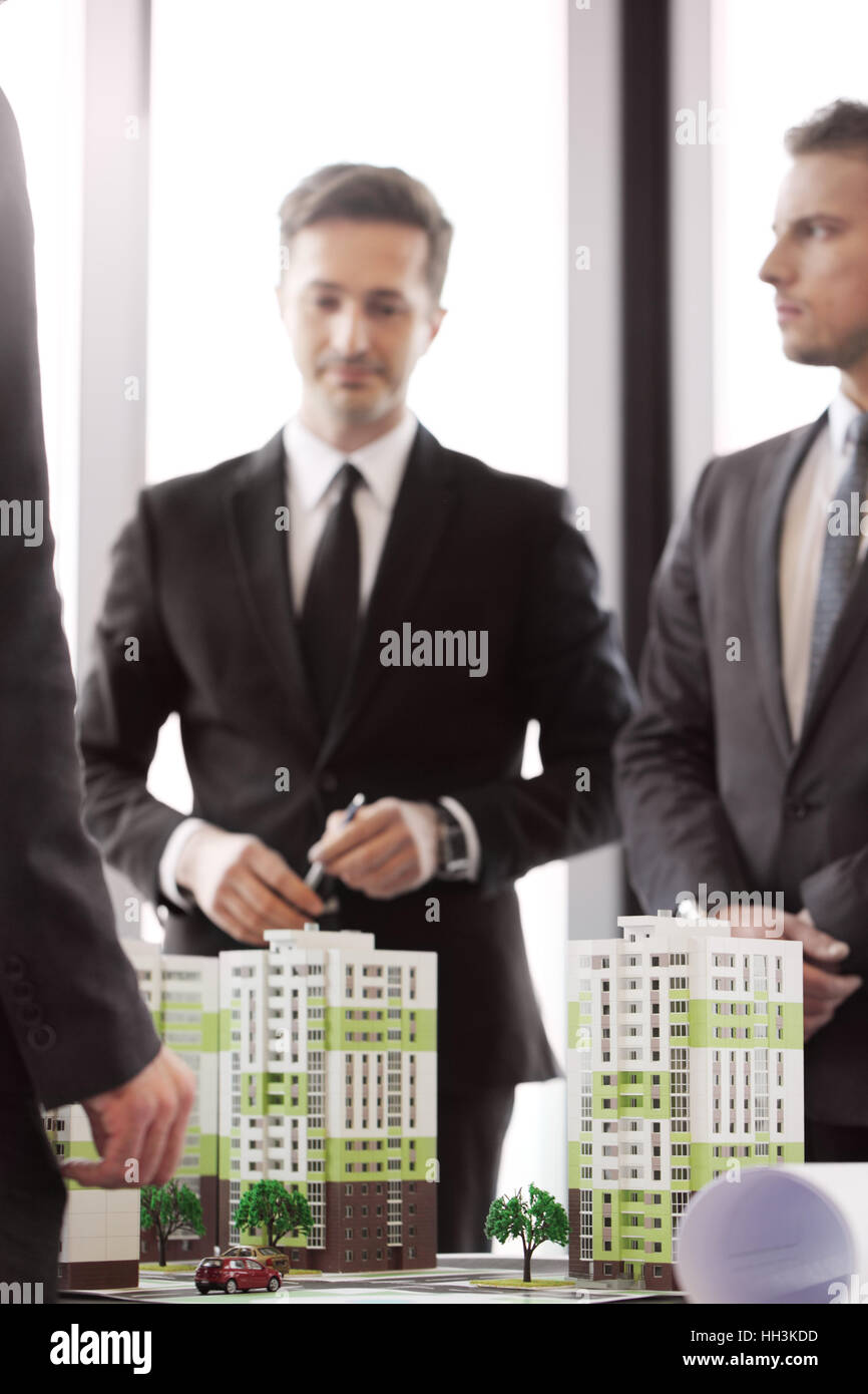 Treffen der Unternehmen, die Leute auf Appartementhaus Quartal Modell schauen Stockfoto