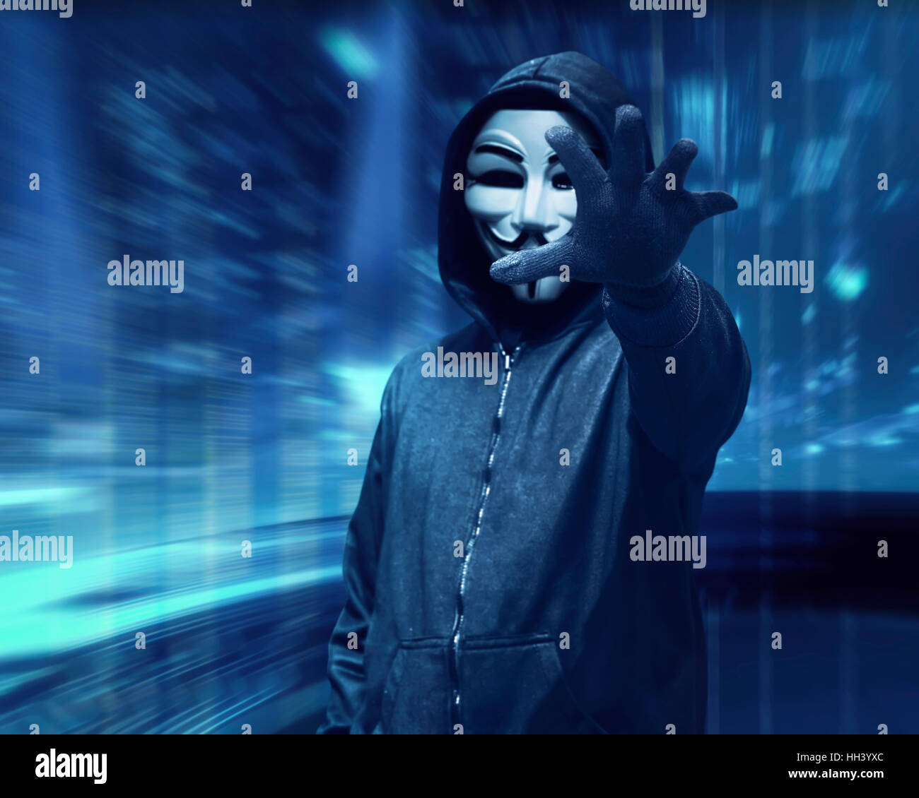 Hacker Mann mit anonymen Maske greifen etwas über Visual Hintergrund Stockfoto