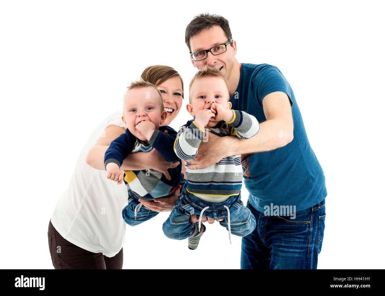 Glückliche Familie mit Zwillingen lacht.  Mutter und Vater sind Holding neu angenommenen Kinder über ihren Köpfen in der Feier der erfolgreichen Verabschiedung. Ist Stockfoto