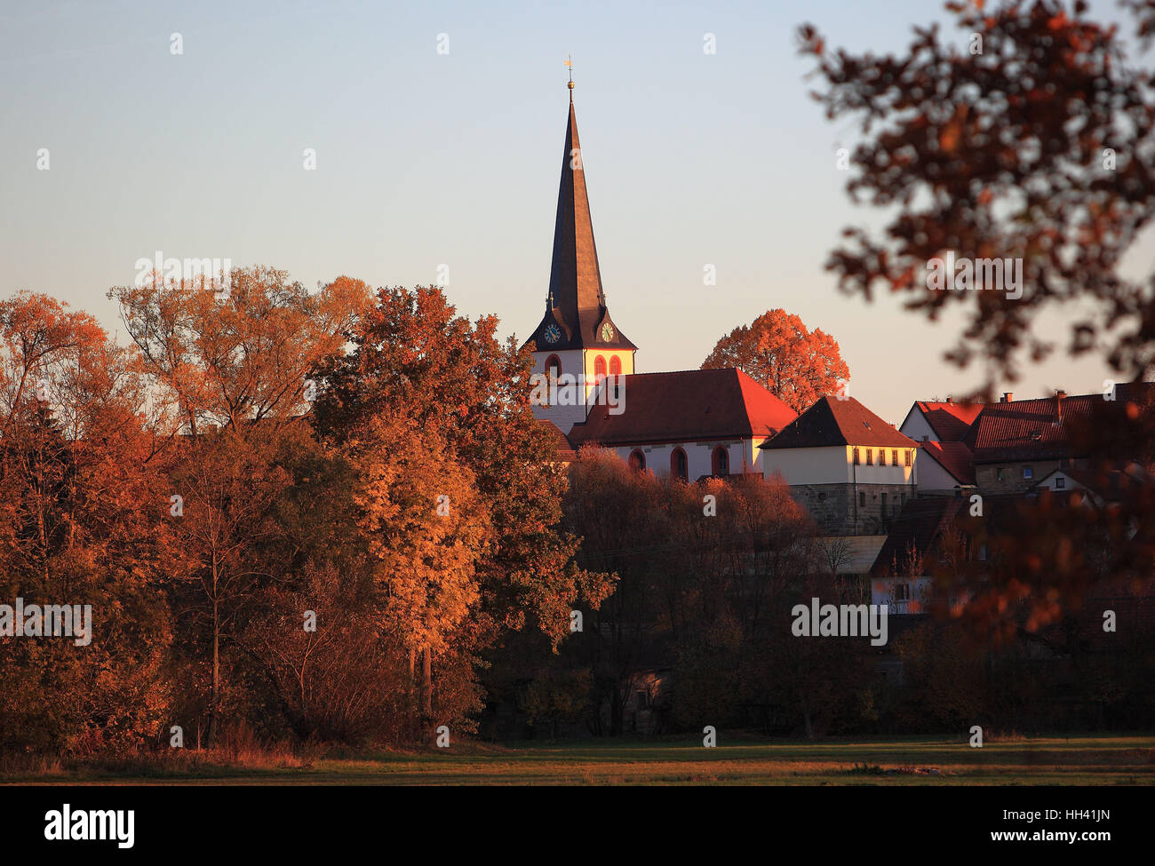 die Oberauhof im Herbst in der Abendsonne und Blick auf die Kirche in Melkendorf, Kulmbach, Upper Franconia, Bayern, Deutschland Stockfoto