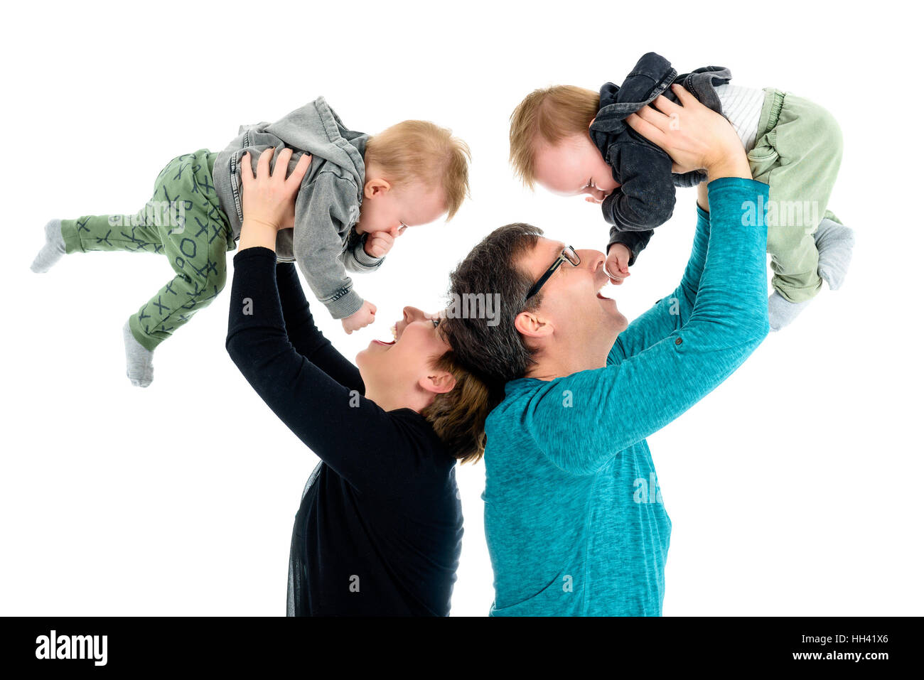 Glückliche Familie mit Zwillingen lacht.  Mutter und Vater sind Holding neu angenommenen Kinder über ihren Köpfen in der Feier der erfolgreichen Verabschiedung. Ist Stockfoto