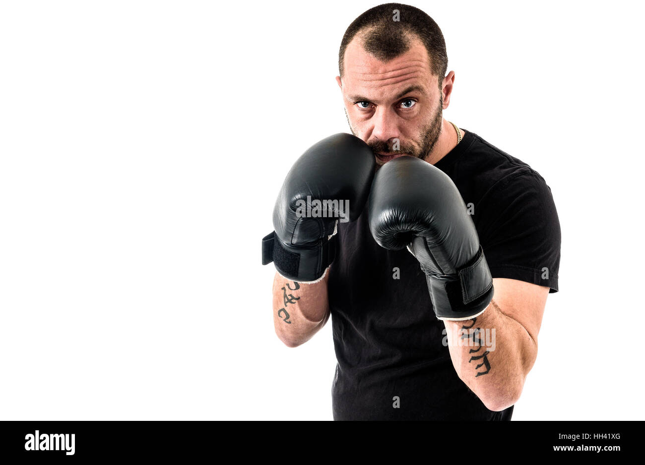 Porträt von männlichen Athleten Boxer Mann aggressiv mit Boxhandschuhen auf schwarzes Hemd und Tätowierungen. Isoliert auf weißem Hintergrund Stockfoto