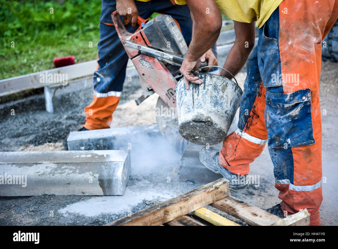 Bau Arbeiter schneiden Betoneinbau ersticht oder Metall für Bürgersteig mit einem Cut-off sah. Profil auf der Klinge ein Asphalt oder Beton Cutter-Witz Stockfoto