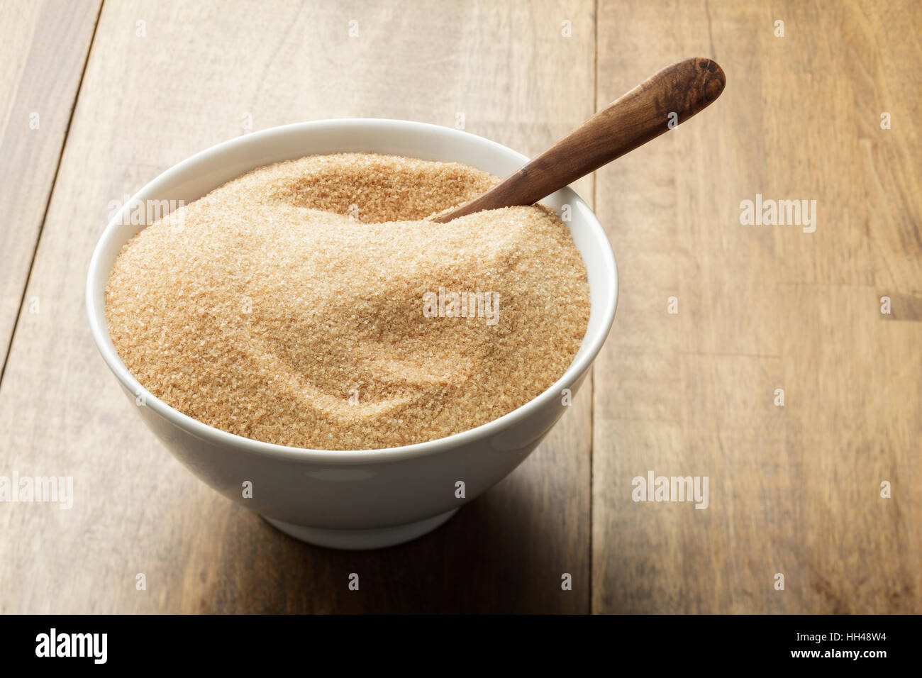 Brauner Zucker in weiße Schüssel auf Holztisch Stockfoto