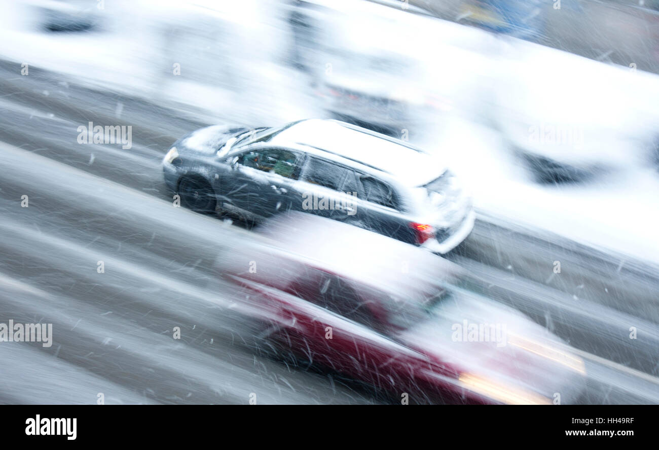 Verschneiter Tag in die Stadt: fahren Autos auf der Straße getroffen durch den Schneefall in Bewegung verwischen Stockfoto