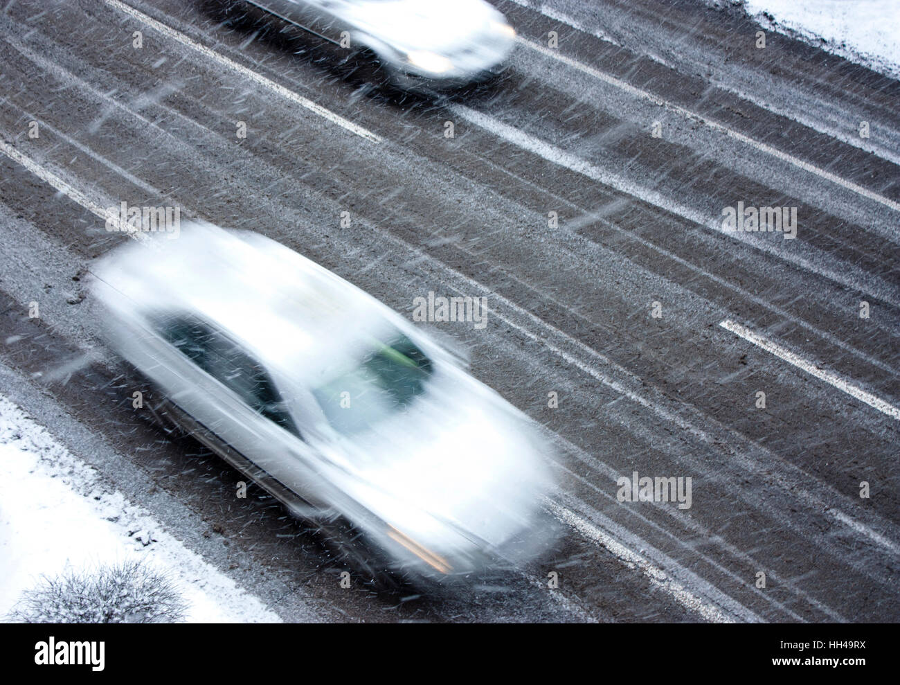 Verschneiter Tag in die Stadt: fahren Autos auf der Straße getroffen durch den Schneefall in Bewegung verwischen Stockfoto
