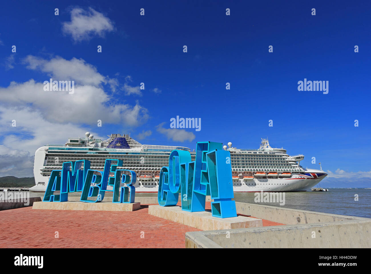 Großes Schild in Kreuzfahrtterminals, Amber Cove, Dominikanische Republik, mit P & O Kreuzfahrtschiff Azura im Hintergrund Stockfoto