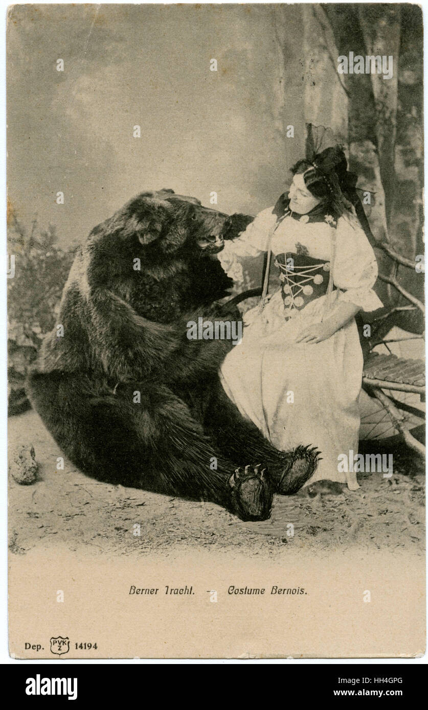 Eine Dame im traditionellen Bernaise-Kostüm, die mit einem Bären posiert Stockfoto