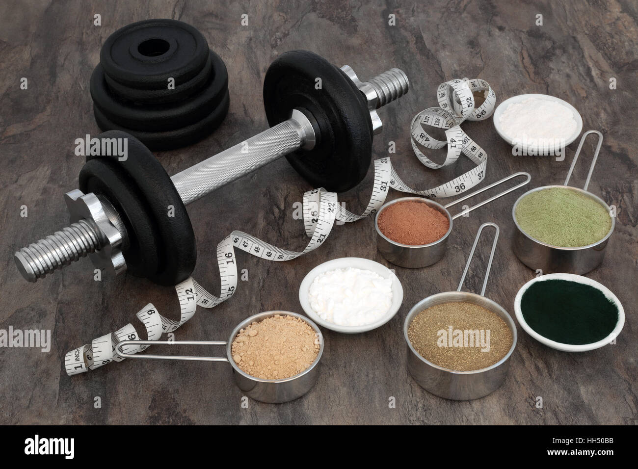 Bodybuilding-Ausrüstung mit Hantel Gewichte, Pulver Nahrungsergänzungsmittel und Maßband über Marmor Hintergrund. Stockfoto