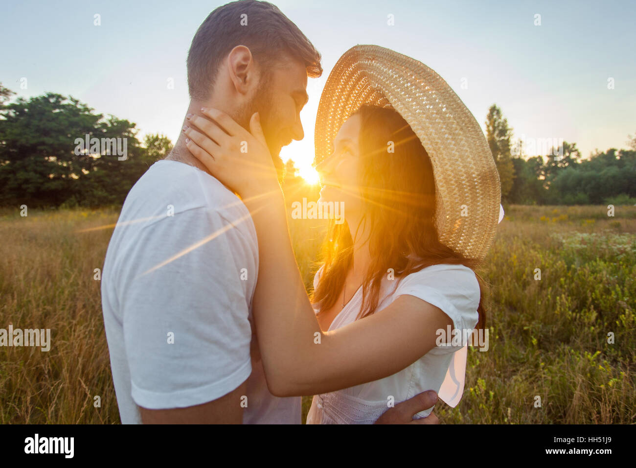 Glückliche schöne Paar umarmt im Park in der auf den Sonnenuntergang. Stockfoto