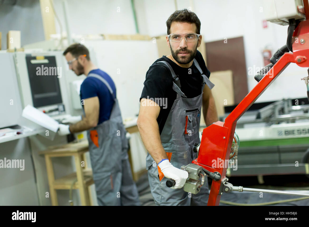 Junge männliche Arbeitnehmer arbeiten in einer Fabrik für die Herstellung von Möbeln Stockfoto