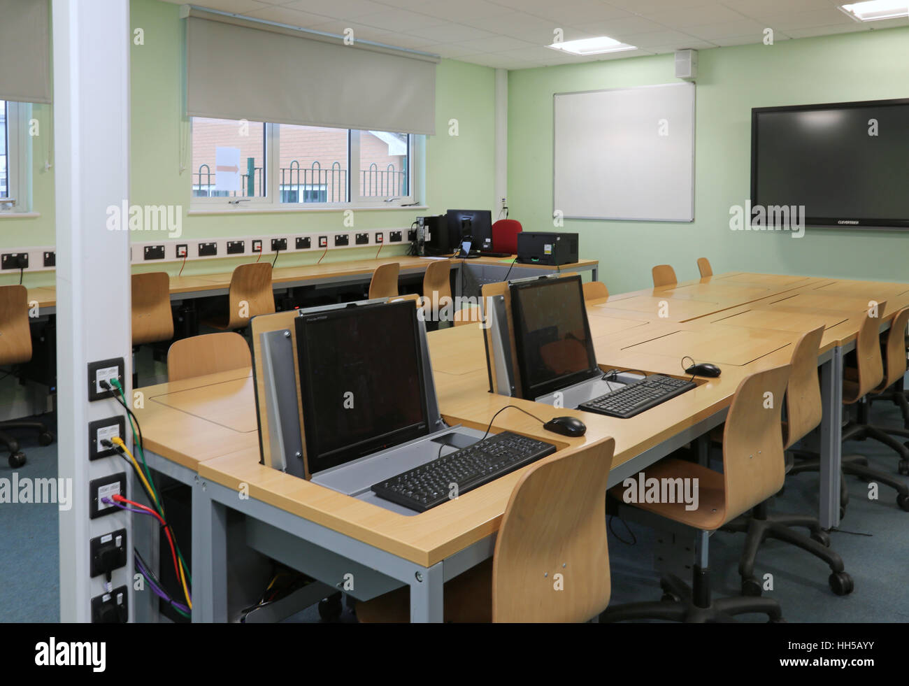 PC-Schreibtische in einer neuen Mittelschule Technologie Klassenzimmer. Zeigt Computer versteckt im besonderen klappbare Tische Stockfoto