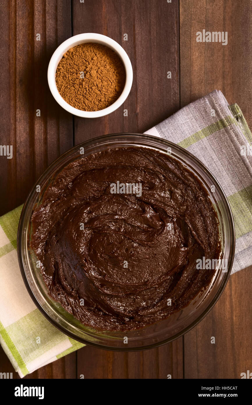 Grundlegende Brownie, Schokoladenkuchen oder Plätzchenteig in Glasschale mit Kakaopulver auf der Seite mit Tageslicht fotografiert Stockfoto