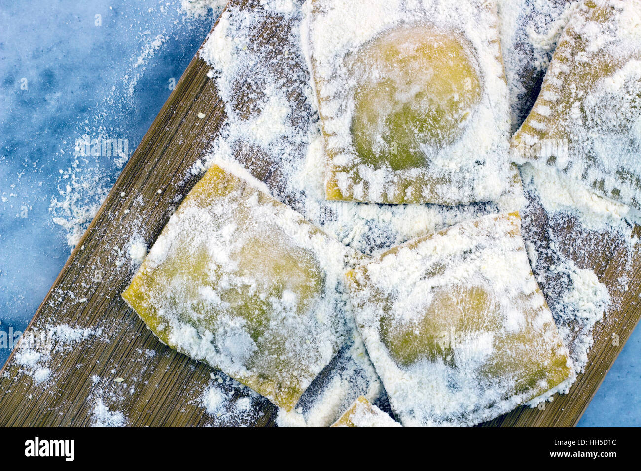 Bemehlten italienischen Ravioli mit schwarzem Pfeffer auf einem Marmor Hintergrund Stockfoto